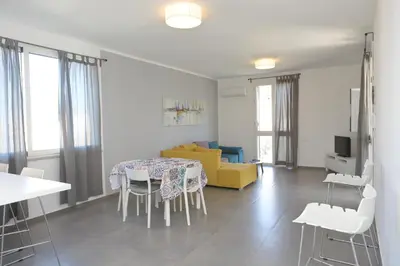 a living room with a table and a yellow couch at Casa Verdemare in Cefalù
