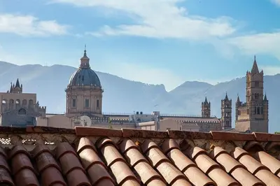 a group of buildings with mountains in the background at Vicoloft al Capo in Palermo