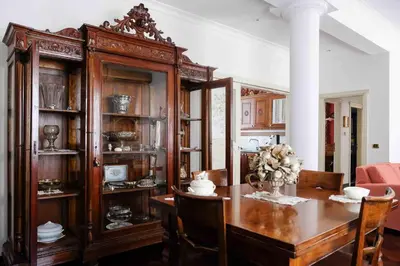 a dining room with a table and a large wooden cabinet at High-end apartment in the city center in Palermo