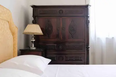 a large wooden dresser in a bedroom with a bed at High-end apartment in the city center in Palermo