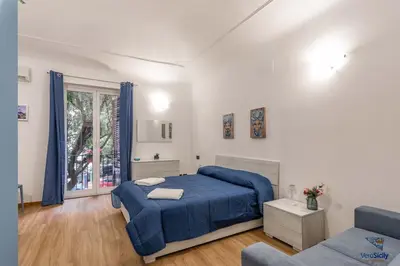 a bedroom with a blue bed and a couch at Al Mondellu apt Verosicily in Palermo