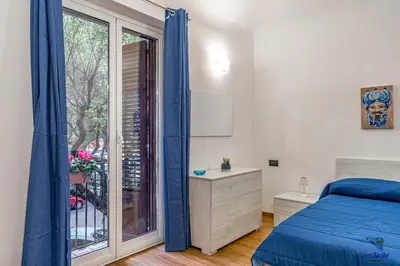 a bedroom with a blue bed and a window at Al Mondellu apt Verosicily in Palermo
