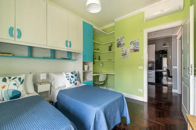 two beds in a room with green walls at Sunny Suite Palermo in Palermo