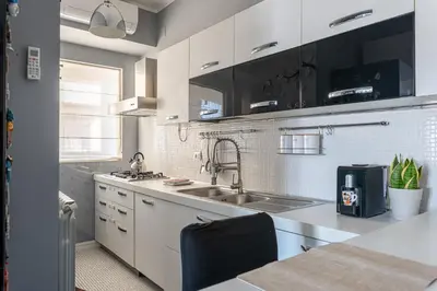 a kitchen with white cabinets and a sink at Sunny Suite Palermo in Palermo