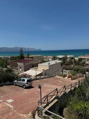 a car parked in a parking lot next to the beach at Sea view terrace house in Alcamo