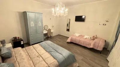 a bedroom with two beds and a chandelier at Vanila Dream's House in Palermo