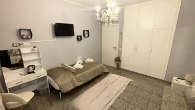 a bedroom with a bed and a desk and a television at Vanila Dream's House in Palermo