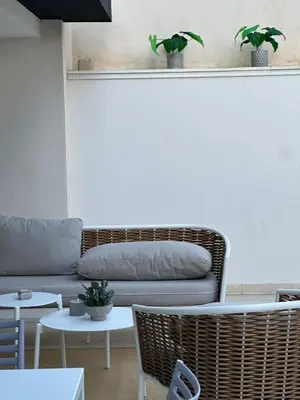 a table and chairs with a bowl of fruit on it at Marina Beach Apartments in Alcamo