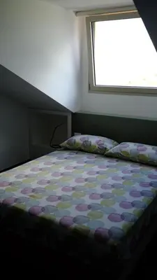 a bedroom with a bed with a flowered comforter and a window at Nereide home 350 sqm with large garden in Balestrate