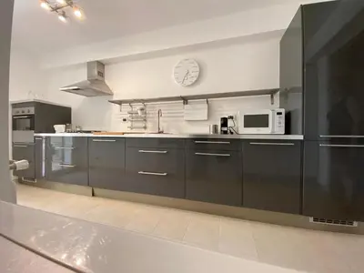 a kitchen with black cabinets and a microwave at Nereide home 350 sqm with large garden in Balestrate