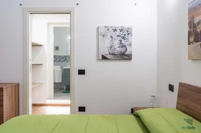 a couch in a living room with two paintings on the wall at Ballaria in Palermo