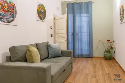 a bedroom with a green bed and a large window at Ballaria in Palermo