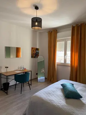 a bedroom with a bed and two tables with lamps at Kayu Home in Palermo