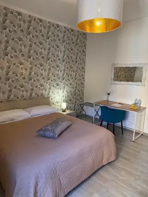 a table with a lamp on it next to a bed at Kayu Home in Palermo