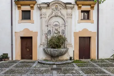 a building with a fountain in front of a building at Casa Dara By DomuSicily in Palermo