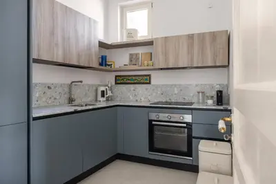 a small kitchen with blue cabinets and a stove at Casa Dara By DomuSicily in Palermo