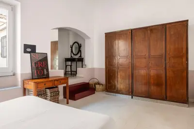 a bedroom with a large wooden closet and a table at Casa Dara By DomuSicily in Palermo