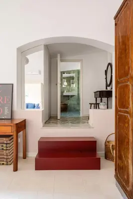 a living room with a red bench and a piano at Casa Dara By DomuSicily in Palermo