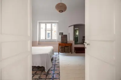 a white bedroom with a bed and a window at Casa Dara By DomuSicily in Palermo