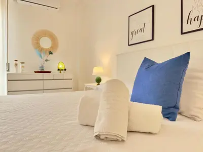 a bedroom with a white bed with blue pillows at Merlo Holiday Homes Attico in Palermo