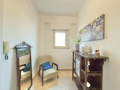 a living room with a chair and a table at Merlo Holiday Homes Attico in Palermo