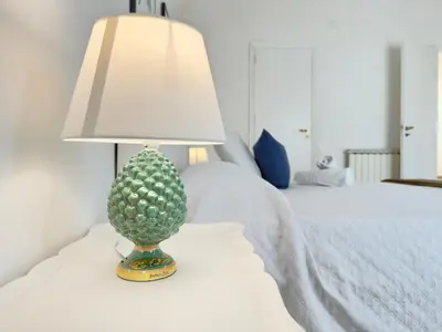 a lamp sitting on a table next to a bed at Merlo Holiday Homes Attico in Palermo