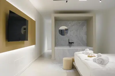 a bathroom with a bath tub and a television at Aloe -lounge and Jacuzzi- in Palermo