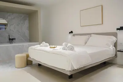 a bedroom with a white bed and a bath tub at Aloe -lounge and Jacuzzi- in Palermo