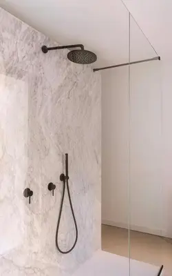 a shower in a bathroom with a marble wall at Aloe -lounge and Jacuzzi- in Palermo