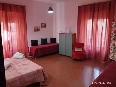 a bedroom with two beds and a red chair at Nanà in Movida in Palermo
