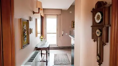 a room with a table and a clock on the wall at Agelina square Home Gibellina in Nuova Gibellina