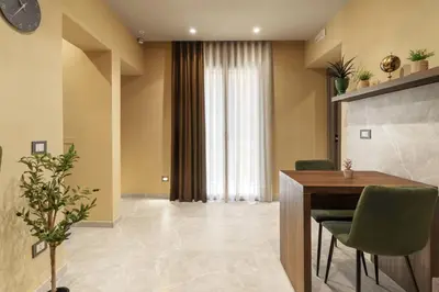 a dining room with a table and green chairs at La Piazzetta Sea Rooms in Balestrate