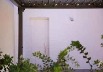 a white door in a white building with plants at Solemar Sicilia - Casa Belle in Palermo