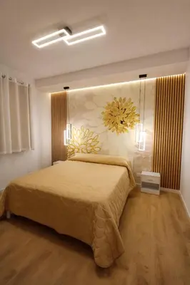 a bedroom with a blue bed with a flower mural on the wall at Scrusciu Holiday in Terrasini