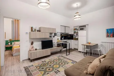 a living room with a couch and a tv and a kitchen at Carducci Apartment By DomuSicily in Palermo