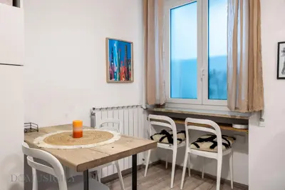 a dining room with a table and chairs and a window at Carducci Apartment By DomuSicily in Palermo