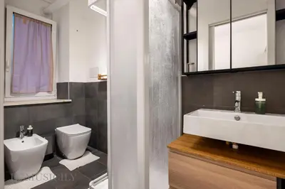 a bathroom with a white sink and a toilet at Carducci Apartment By DomuSicily in Palermo