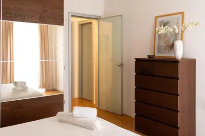 a bedroom with a bed and a dresser and a mirror at The Nest Maqueda in Palermo
