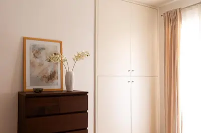 a bedroom with a cabinet and a dresser with flowers on it at The Nest Maqueda in Palermo