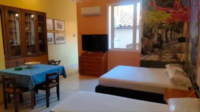 a room with a bed and a table and a television at Casa degli Angeli Castellammare del Golfo TP Sicilia in Castellammare del Golfo
