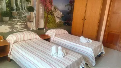 two beds with slippers on them in a room at Casa degli Angeli Castellammare del Golfo TP Sicilia in Castellammare del Golfo