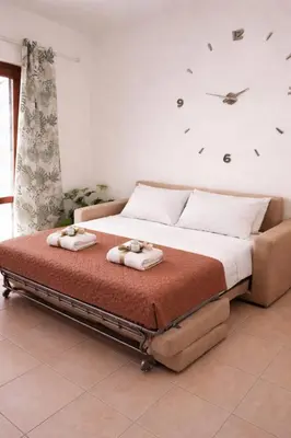 a bedroom with a bed with a white blanket and a plant at Blossom House in Isola delle Femmine
