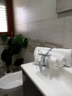 a bathroom with towels with a bow on a sink at Blossom House in Isola delle Femmine