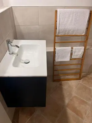 a bathroom with a white sink and a towel rack at RossoScirì in Calatafimi