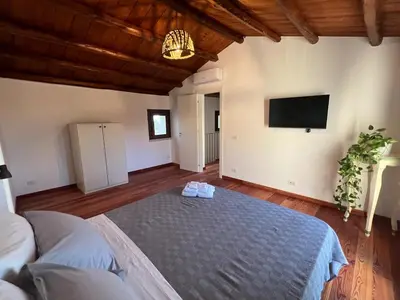 a room with a bed and a tv on the wall at RossoScirì in Calatafimi