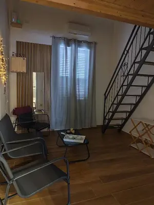 a living room with a couch and a staircase at Appartamento La Perla bianca in Palermo