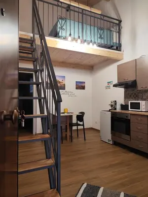 a kitchen and dining room with a spiral staircase in a loft at Appartamento La Perla bianca in Palermo