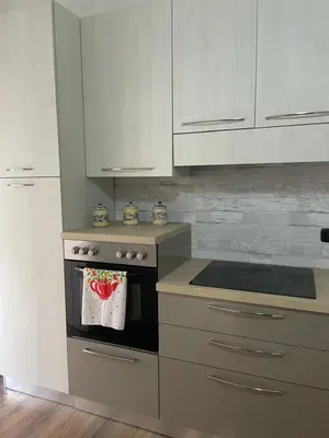 a kitchen with white cabinets and a stove top oven at Luma Sixty nine in Alcamo