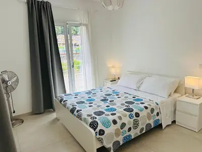 a bedroom with a bed with a blue and white comforter at Casa Battigia in Alcamo
