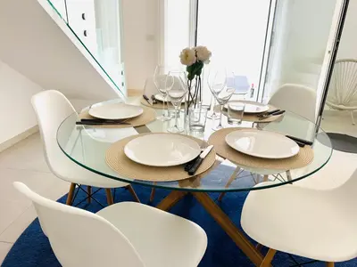 a dining room with a glass table and white chairs at Casa Battigia in Alcamo